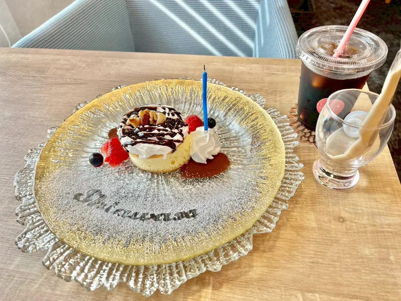 ろうそくを立てたパンケーキとアイスコーヒー