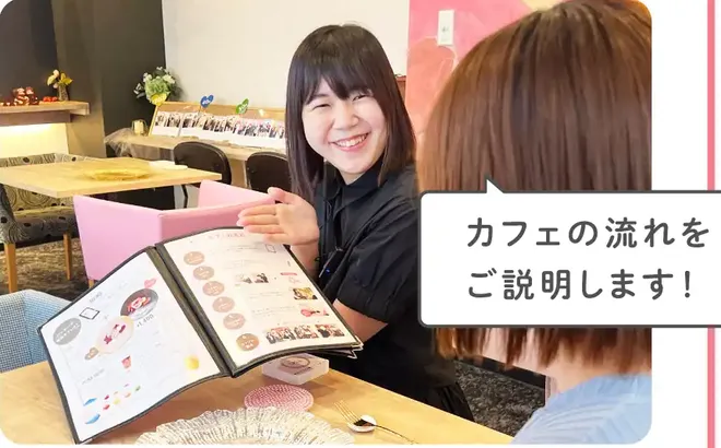 スタッフがメニューを開いてお客様に説明している写真。吹き出し「カフェの流れをご説明します!」