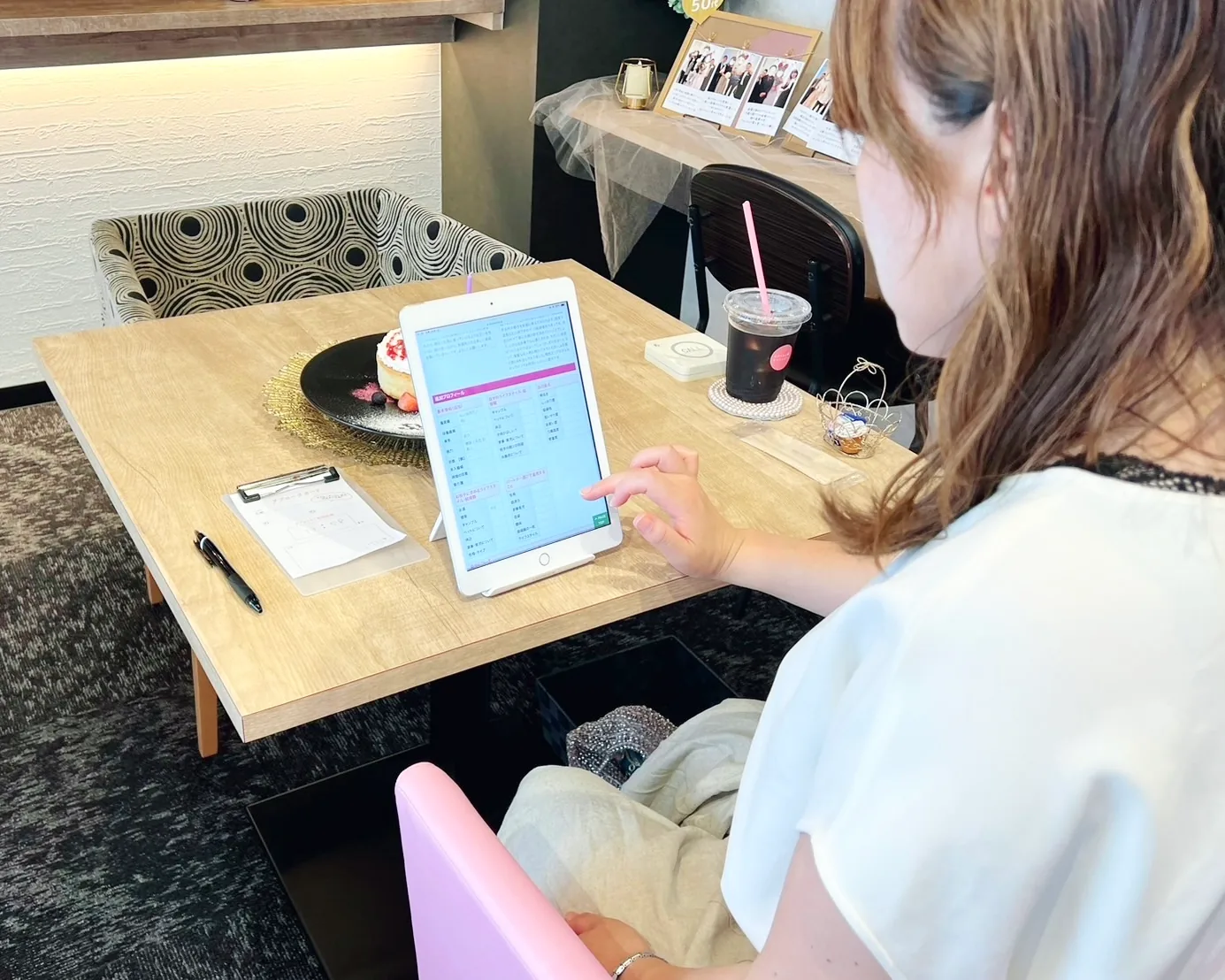 パンケーキとドリンクを前に、婚活タブレットを操作している女性のお客様の写真